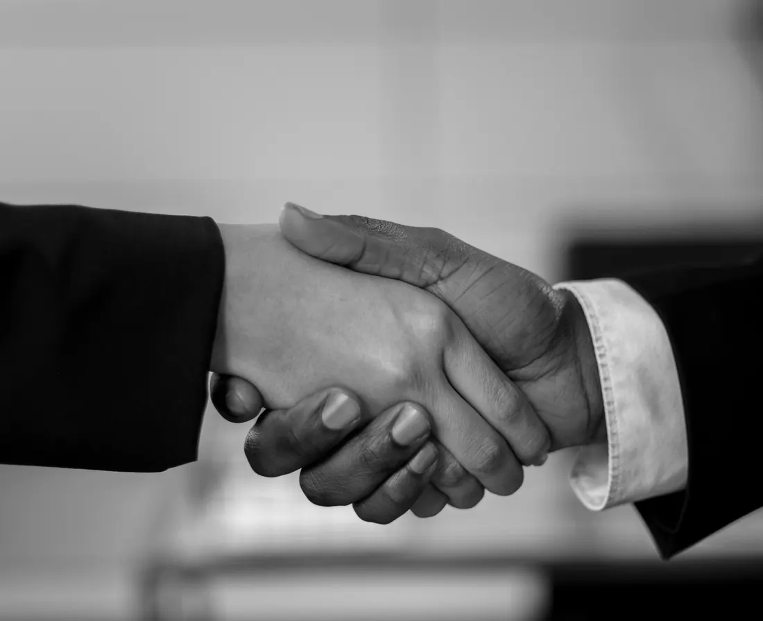 Black-and-white close-up of two business professionals shaking hands
